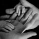 black and white image of a set of hands holding a set of a baby'd hands